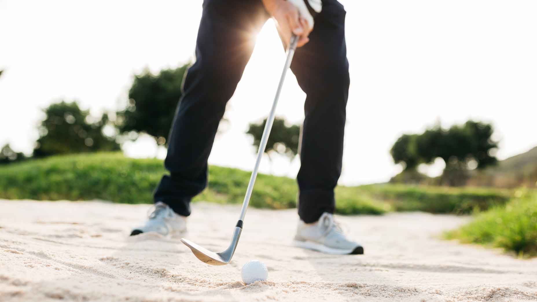 Golfer setting up to bunker shot
