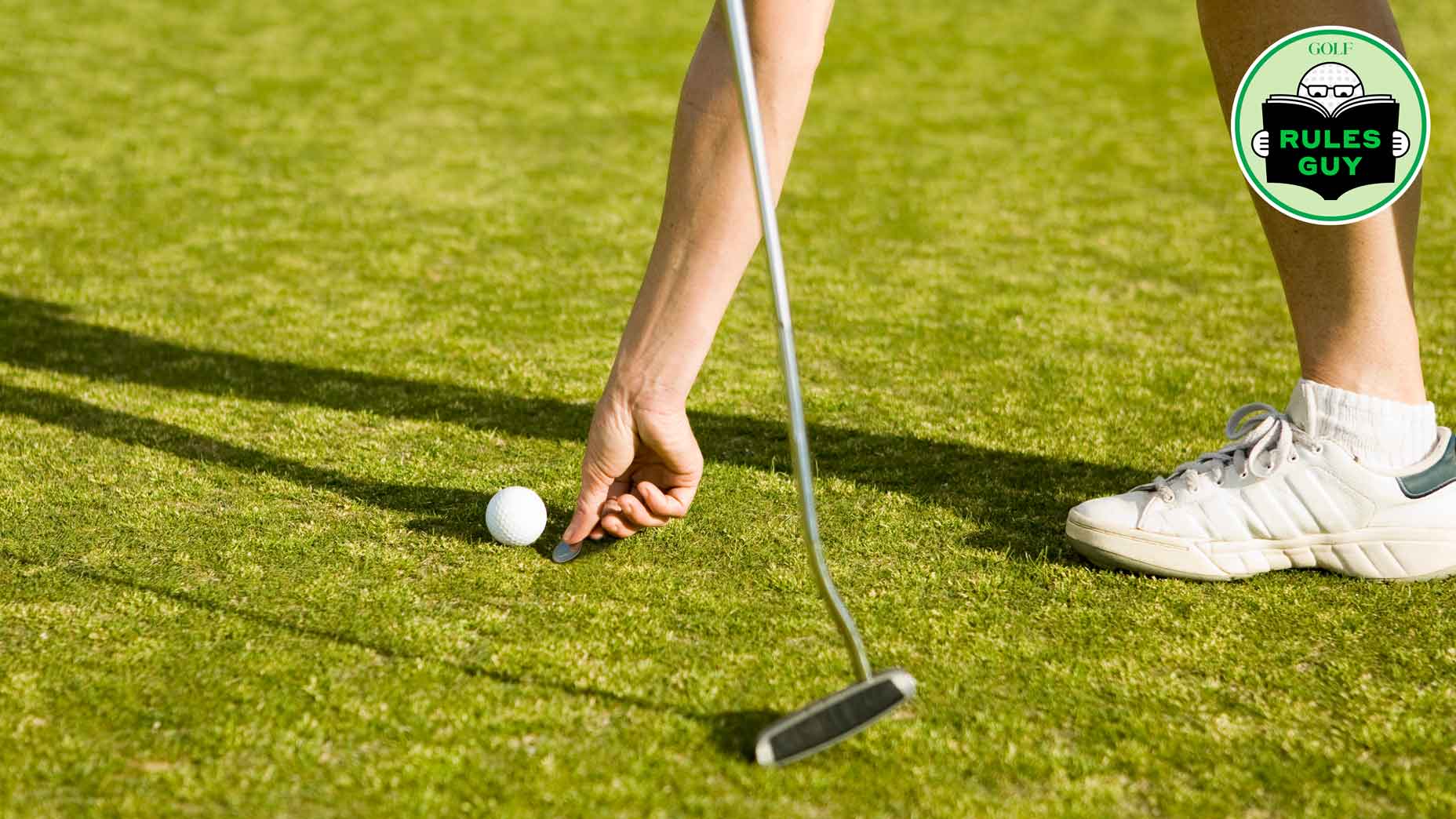 Detail of a golfer marking the ball's position with a coin - stock photo